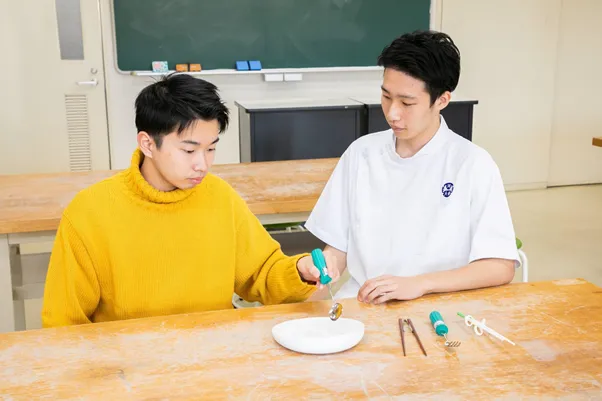 作業療法士と男性が手指を使用したリハビリを行っている様子。