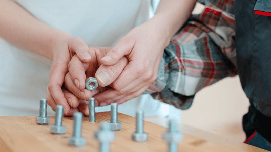 作業療法士が患者さんと手指の訓練を行っている様子の画像。