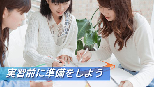 机を囲んで勉強をしている大学生のイメージ