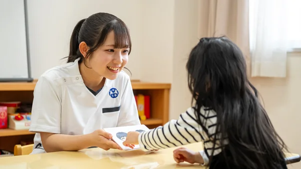 子どもと向かい合わせで座る言語聴覚士のイメージ